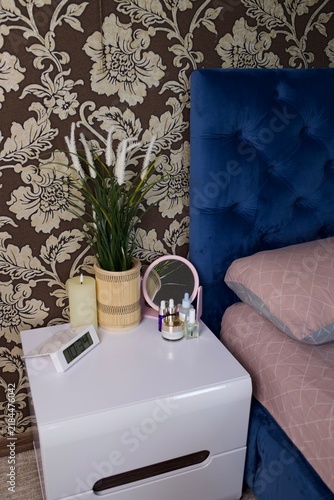 Canvas Print Close view of bedroom bedside decor showing white nightstand with digital alarm