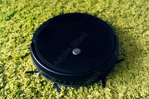 Foto cleaning fleecy carpet with an automatic vacuum cleaner