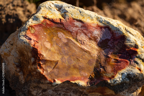 Fotografía Close-up of a raw flint stone displaying vibrant red iron oxide patterns and nat