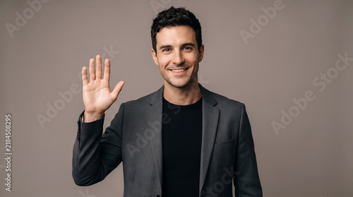 Professional man in a blazer waving to camera, greeting, business, man, portrait, friendly