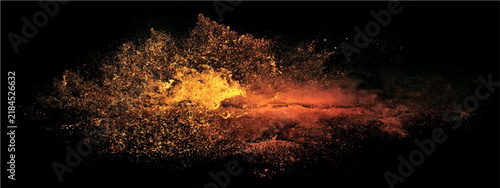 Explosion of vibrant orange and yellow dust particles against a dark background during a dynamic event