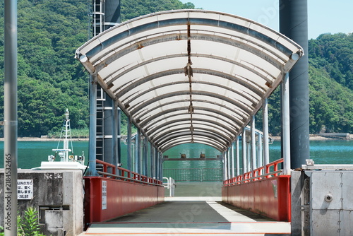 Konstfotografi 広島県大崎上島の夏のフェリー桟橋に伸びるアーチ屋根の通路と青緑の海