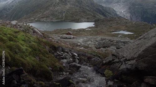 Idyllischer Bergbach in den Schweizer Alpen mit Blick zum Bergsee - Schweizer Bergpässe Grimsel Pass Berner Oberland