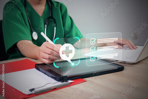 Female Doctor Using Stylus Pen on Tablet Screen with Hologram Medical Checklist Interface