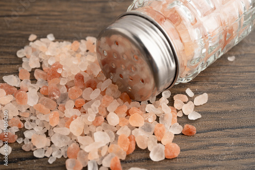 Fotografie Sodium chloride Himalayan pink salt with salt shaker.