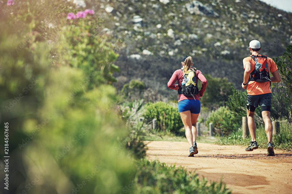 Obraz premium Training, outdoor and couple with backpack, running and physical activity with partner and wellness. Runner, back and people with endurance, together and exercise for fitness or cardio in nature