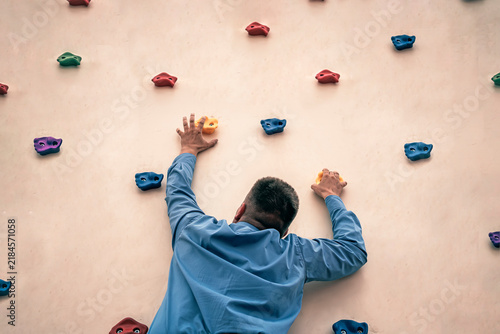 Bild auf Leinwand Businessman with cravat climbing a rock