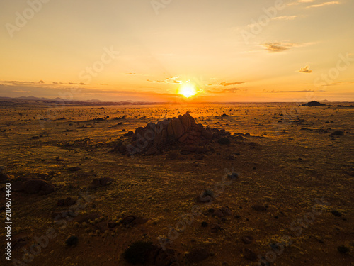 фотографія Rock outcrop silhouetted against a desert sunset