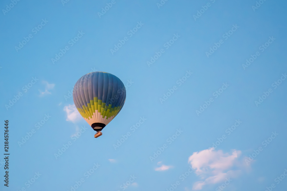 Fototapeta premium Single hot air balloon floating in blue sky over Cappadocia