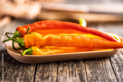 Close-Up of Long Orange and Red Chili Peppers on Rustic Wooden Table Tray, Fresh