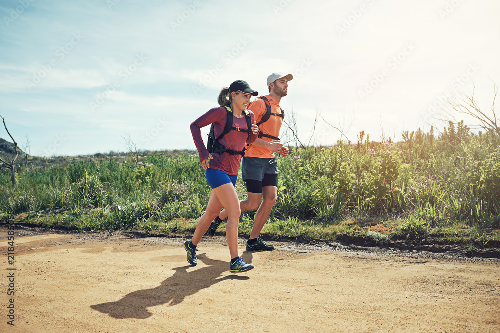 Fototapeta premium Outdoor, travel and happy couple with backpack, running and exercise routine with partner or active. Runner, wellness and people with endurance, space and workout for fitness and bonding in nature