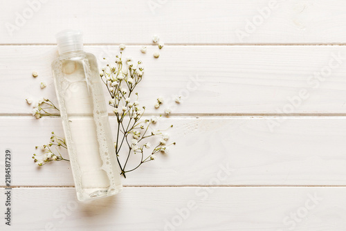 Fancy healthcare bottles for serum, micellar, tonic, toner, lotion, water and cream with gypsophila branch. Natural oranic spa cosmetics concept. Mockup, template, Top view