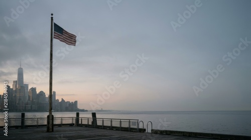 American flag waves proudly over serene waterfront dawn representing hope remembrance following september eleventh tragedy