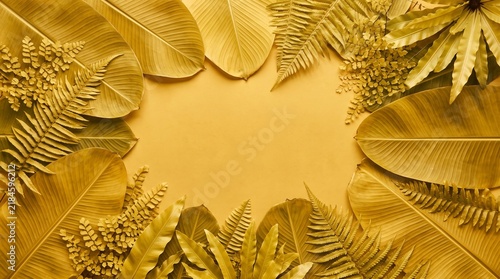 Dried tropical leaves and ferns on yellow background