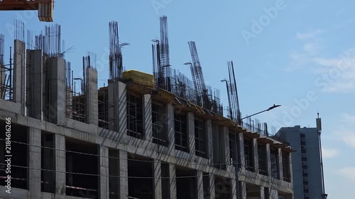 Construction site showing a modern high rise building under development with reinforced concrete structure, steel rebar and unfinished floors, representing urban growth, engineering and architecture
