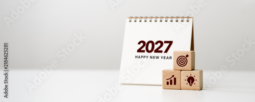 Business goal setting in 2027, future planning, new year resolutions, strategy. 2027 New Year calendar with wooden blocks target, growth, and ideas icons. business success concept.