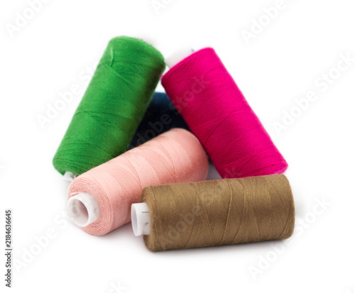 Foto Five colorful spools of sewing thread in green, pink, peach, brown, and dark blu