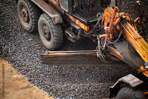 Quadro su tela Heavy duty motor grader machinery actively works to level uneven surface of road