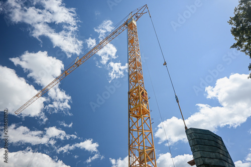 фотографія Heavy duty yellow tower crane lifting counterweights at a construction site