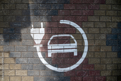 Charging point for electric cars is seen on the ground in a parking area during daylight.