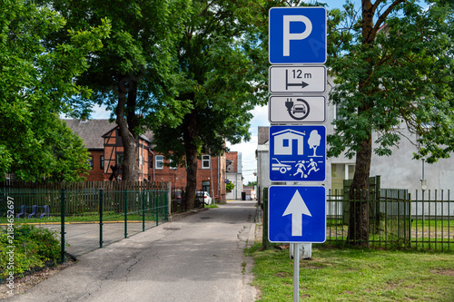 Road signs indicating parking options and nearby facilities in a city area