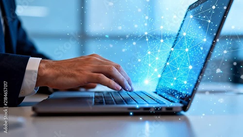 Professional using laptop displaying digital network graphics in bright modern office