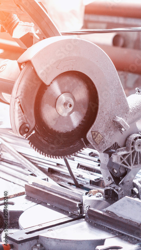 Foto Close up view of miter saw circular blade on metal profiles, showing tool dust a