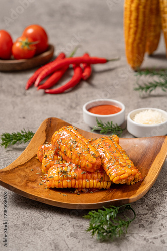 Bild auf Leinwand Grilled corn chunks sprinkled with parsley, slathered with sauce and sprinkled with cheese