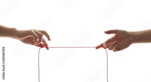 Two hands holding a red thread representing connection and destiny