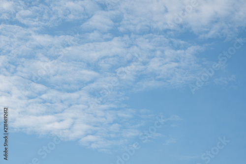 фотографія Clear blue sky with scattered wispy clouds, soft sunlight and a serene atmosphere highlighting natural beauty