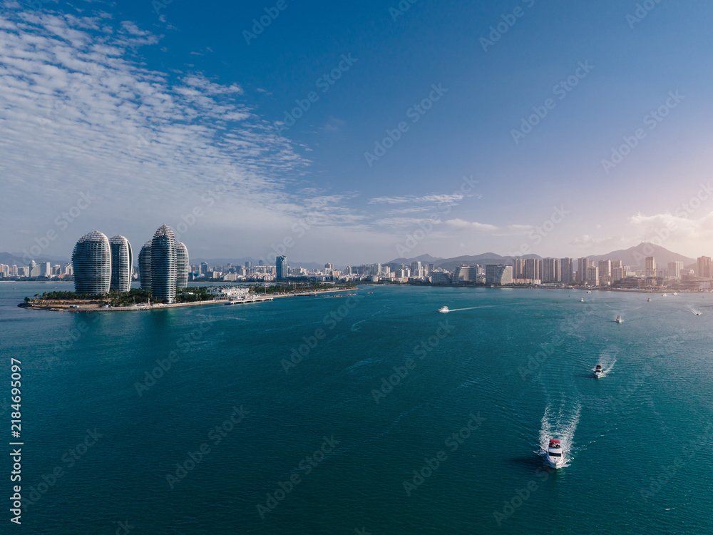 Obraz premium Aerial view of coastal city bay with boats and island towers Sanya Hainan Island, China