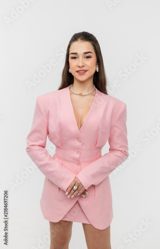 A beautiful schoolgirl in a classic pink suit against a white background.