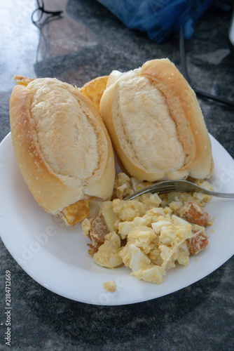 Plate of potato salad with hard-boiled eggs and sausage served with bread