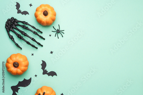 Obraz na plátně Orange pumpkins bats skeleton hand spider on mint background festive Halloween decor