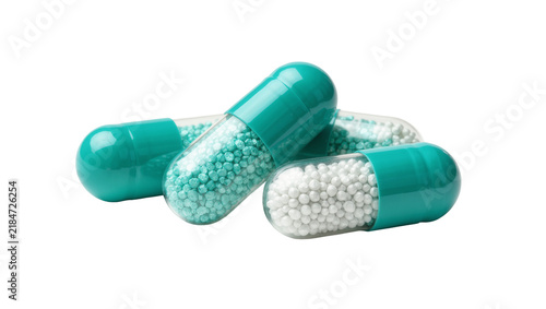 Quadro su tela Teal and clear gelatin capsules filled with tiny white and blue beads, isolated