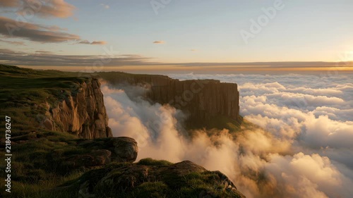 Views from the cliffs at sunset with clouds in the valley below in a distant location