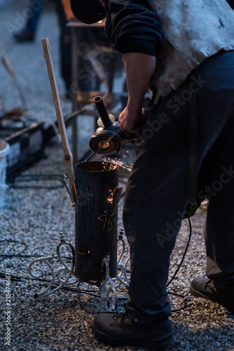 Fotografie Schmied führt ordentliche Schmiedekunst auf dem Weihnachtsmarkt aus