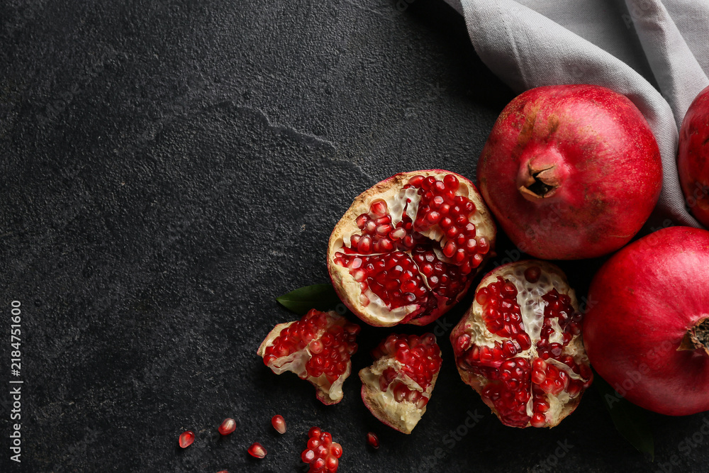 Obraz premium Fresh ripe pomegranates with seeds on dark background