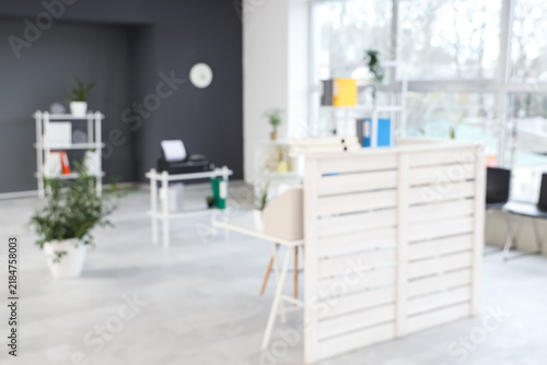 Blurred view of clinic with reception desk and shelf units