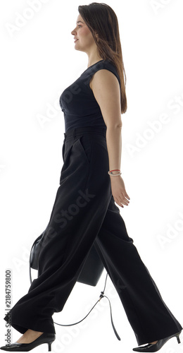 Bild auf Leinwand Businesswoman walks right in black office outfit carrying handbag on transparent background