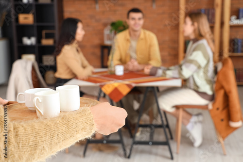Barista bringing coffee to visitors in cafe, closeup