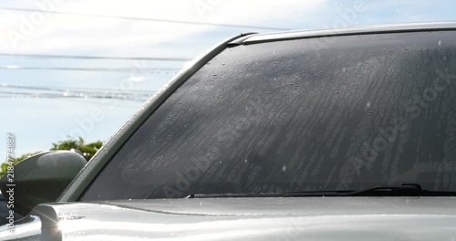 Car Window Reflections: Close-up shot of a car window showing streaks and smudges, Rain is falling on the car windshield; the rainy season and traffic.