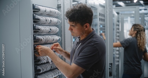 Obraz na płótnie Network Technician Crimps RJ45 Connector Onto Ethernet Cable, Checking Conductor Order Before Termination and Preparing Custom Patch Cord During Structured Cabling Maintenance in Data Center Rack