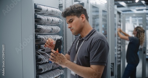 Canvastavla Network Technician Crimps RJ45 Connector Onto Ethernet Cable, Checking Conductor Order Before Termination and Preparing Custom Patch Cord During Structured Cabling Maintenance in Data Center Rack
