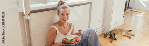 Canvastavla Blonde woman savors a bright morning with a tasty breakfast at home, banner