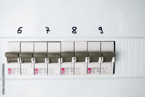 Close up of a modern residential electrical distribution panel with circuit breakers, safety switch and numbered circuits.
