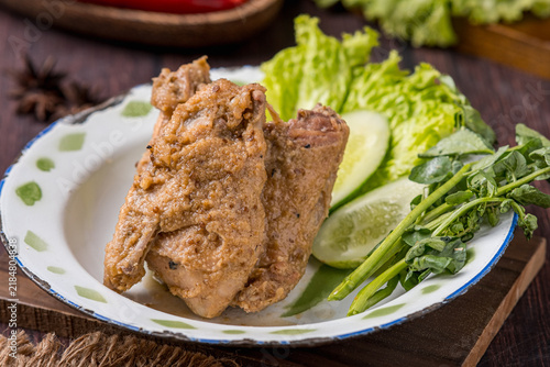 Foto Fried free-range chicken served with lettuce, cucumber, and watercress as accompaniments, plated and photographed against a gray background