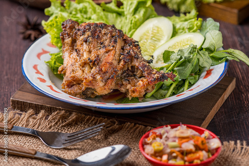 Obraz na plátne Grilled *Tuwuk* free-range chicken—accompanied by lettuce, cucumber, and watercress—is plated and photographed against a gray background