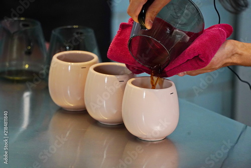 Foto The barista pours specialty coffee from a glass server.