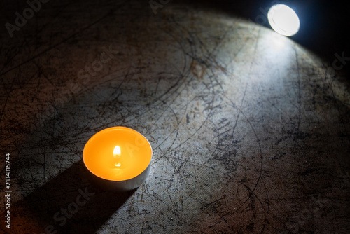 Foto Burning tealight candle in dark atmospheric setting